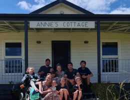 Family smiling at the entrance of Annie's Cottage