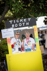 Two volunteers selling tickets for rides at the Very Special Kids Fair