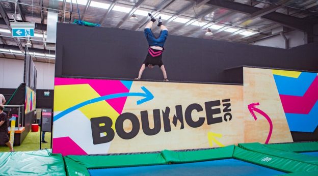 Image of a person doing jumps on an indoor trampoline.