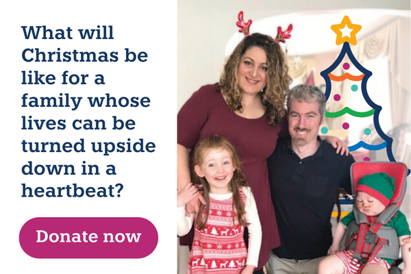 A family of two adults and two children are smiling at the camera, they are wearing Christmas themed clothes and accessories. The text reads: What will Christmas be like for a family whose lives can be turned upside down in a heartbeat? Donate now.